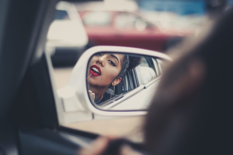 woman in red lips on vehicle by side mirror preview