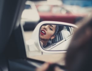 woman in red lips on vehicle by side mirror thumbnail