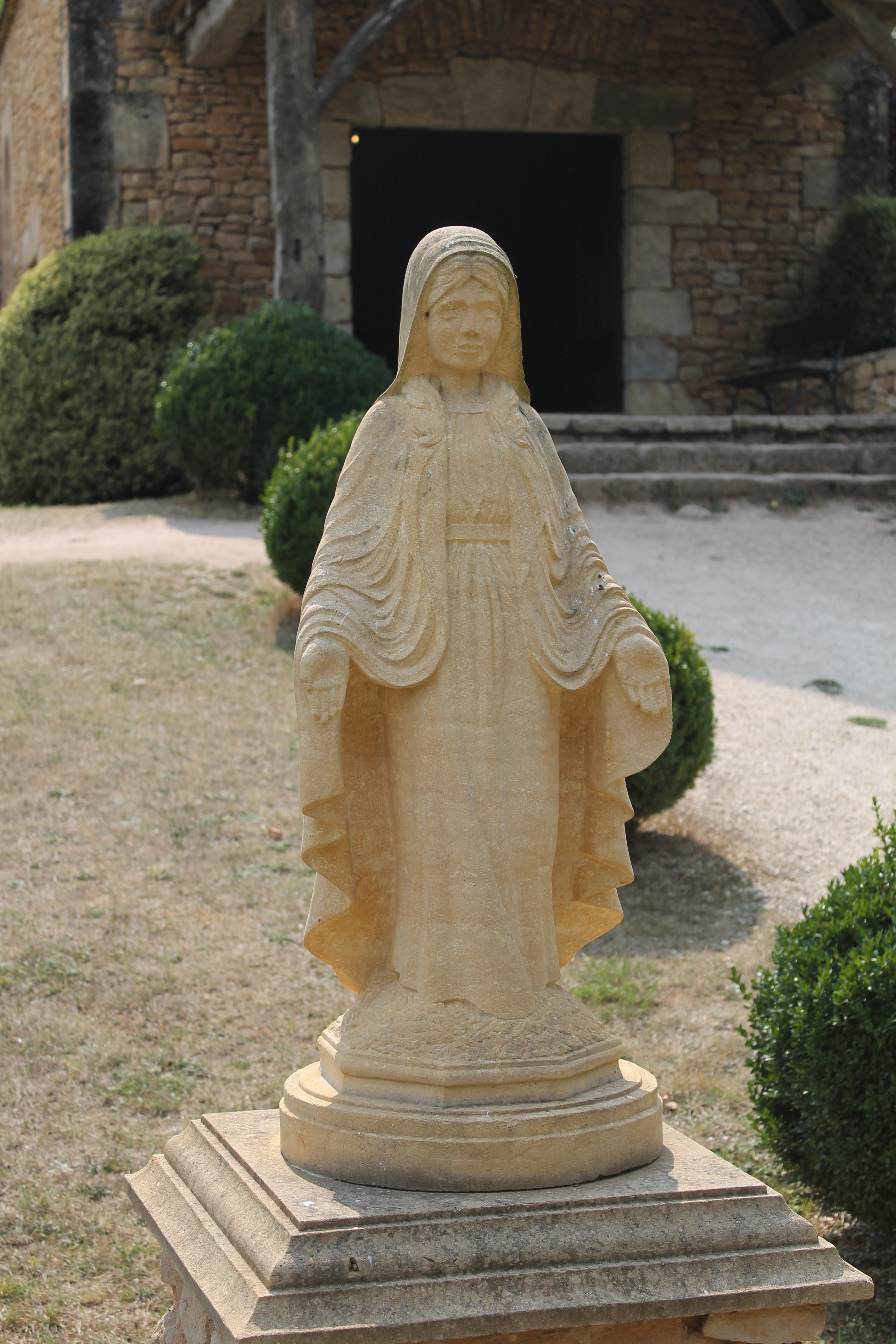 white religious statuette outside the house