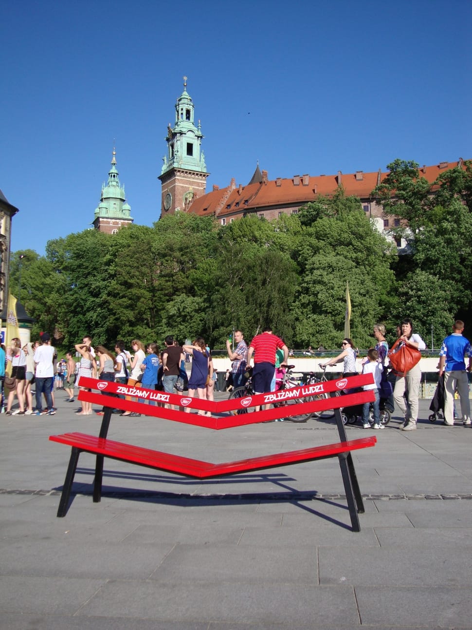 red and black wooden bench in front of group of people during daytime preview