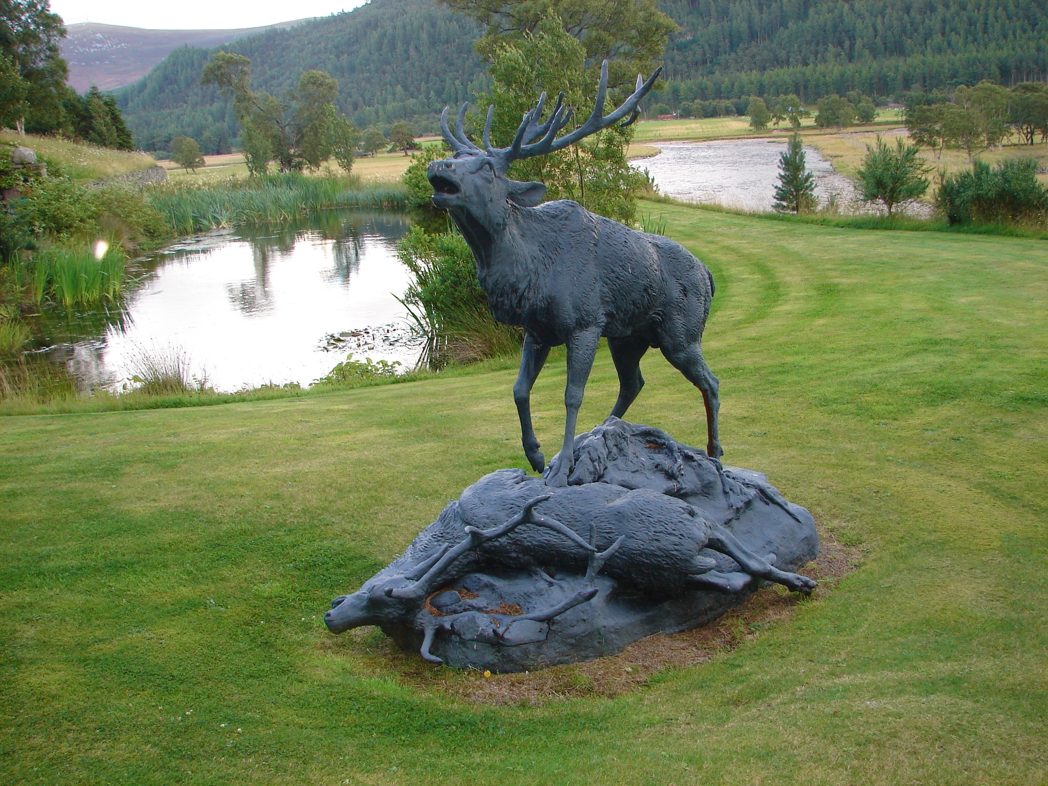 elk standing and lying on rock monument