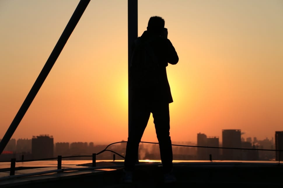 silhouette of man taking a picture to a building preview