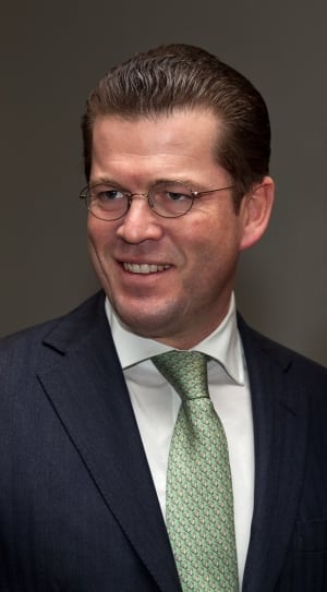 men's black framed eyeglasses, black notch lapel suit jacket and green necktie thumbnail