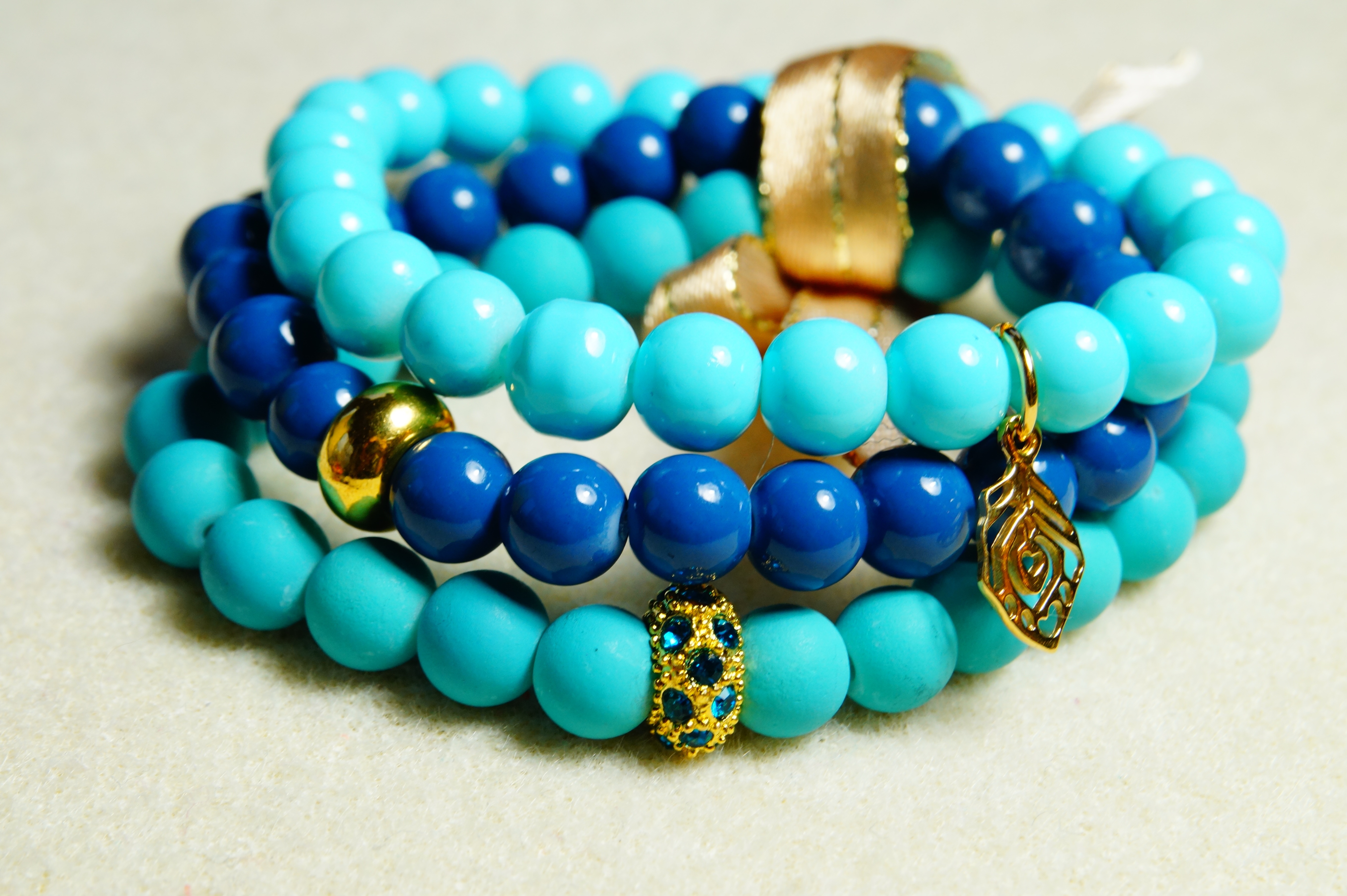 three blue and teal beaded bracelets