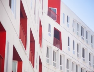 white and red concrete high rise building thumbnail