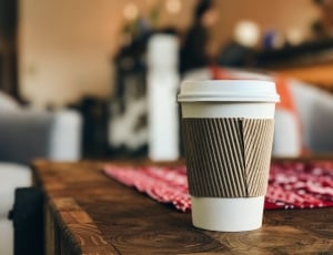 selective focus photo of white and brown disposable cup on table thumbnail