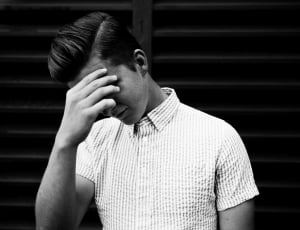 man in collared shirt with face palm in grayscale photo thumbnail