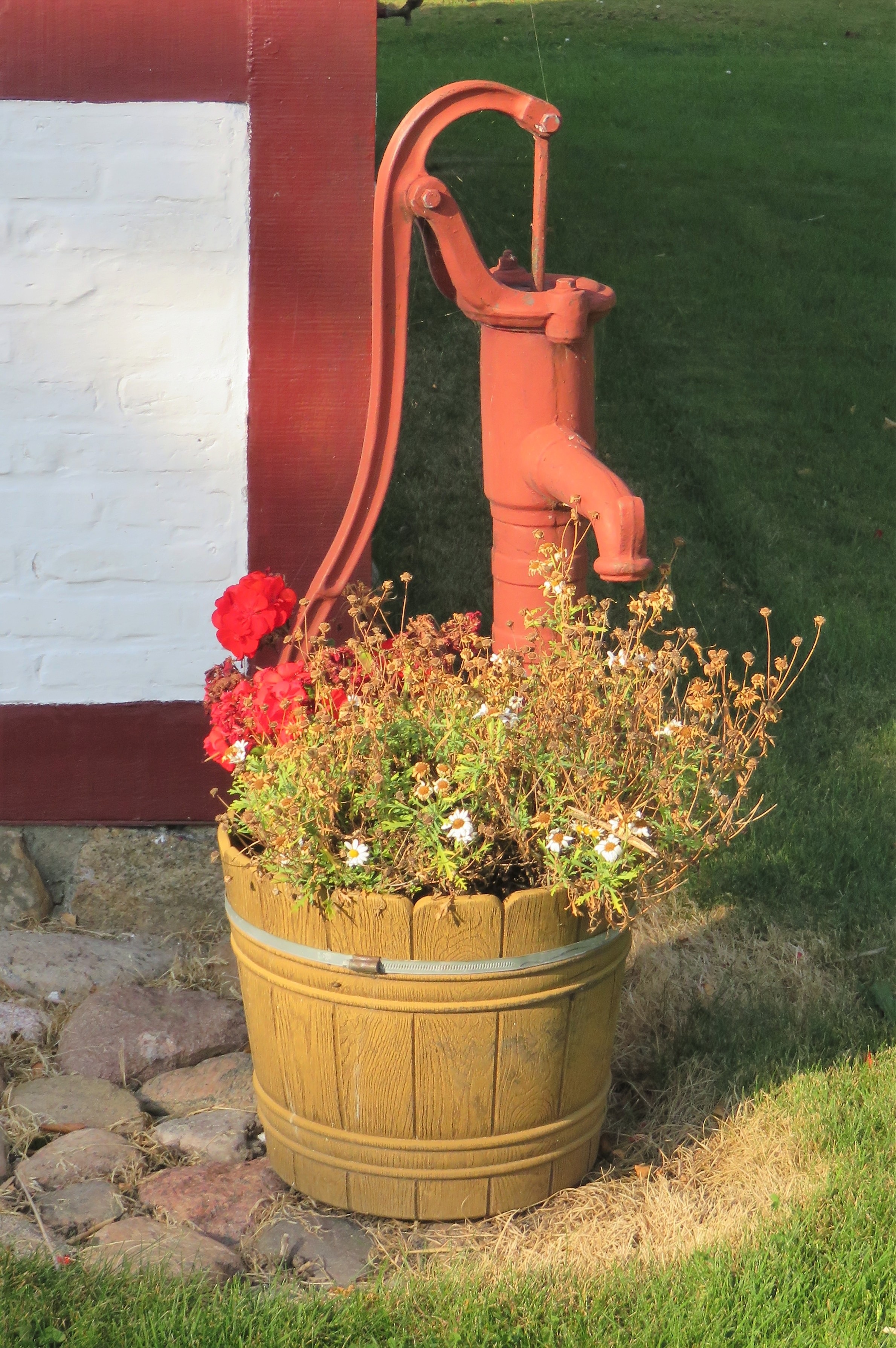 brown wooden pot and red steel water pump