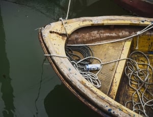 rope on yellow metal boat on body of water thumbnail