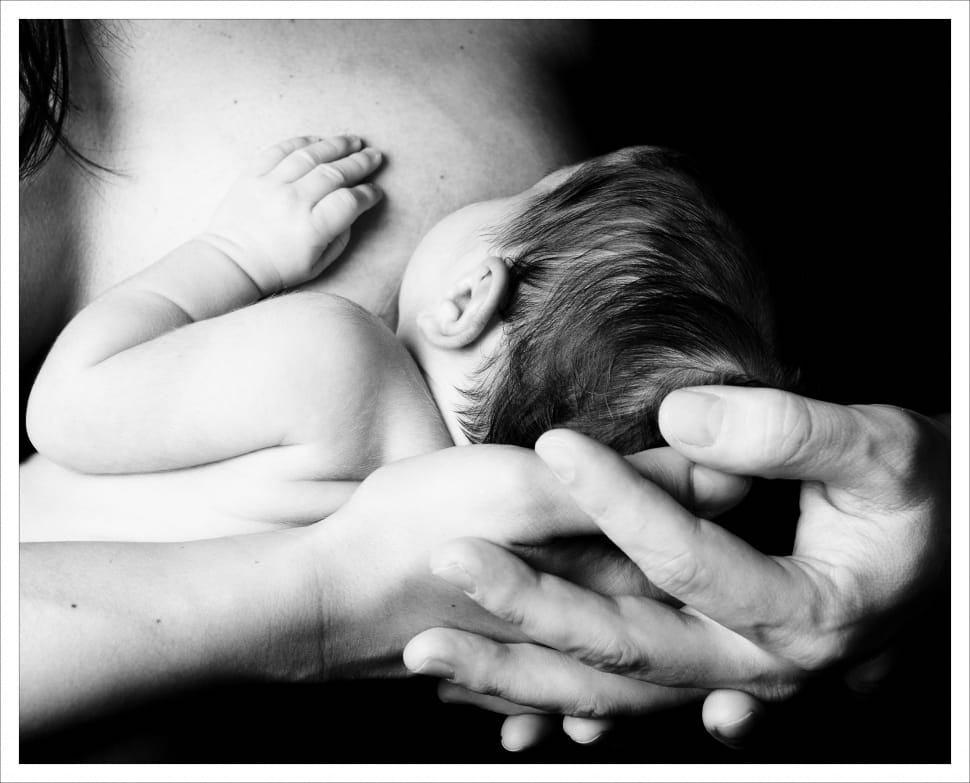 greyscale photograph of baby breast feeding preview