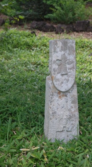 gray concrete statuette on green grass ground thumbnail