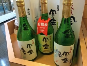 three sake glass bottles near white boxes thumbnail