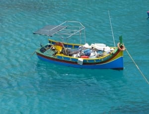 green, blue, and red boat on body of water thumbnail