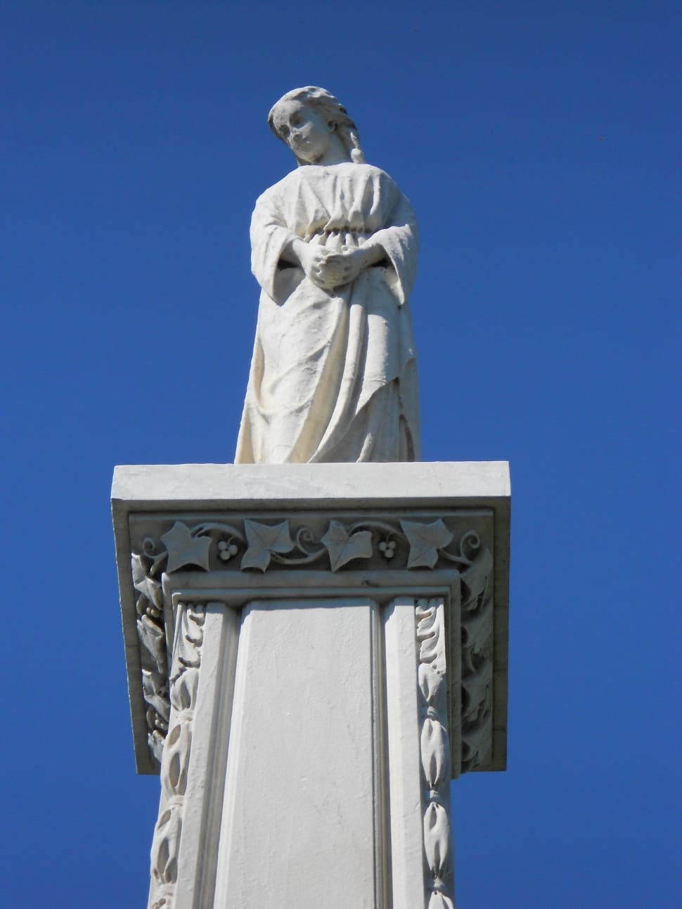 woman statue on white column during daytime preview