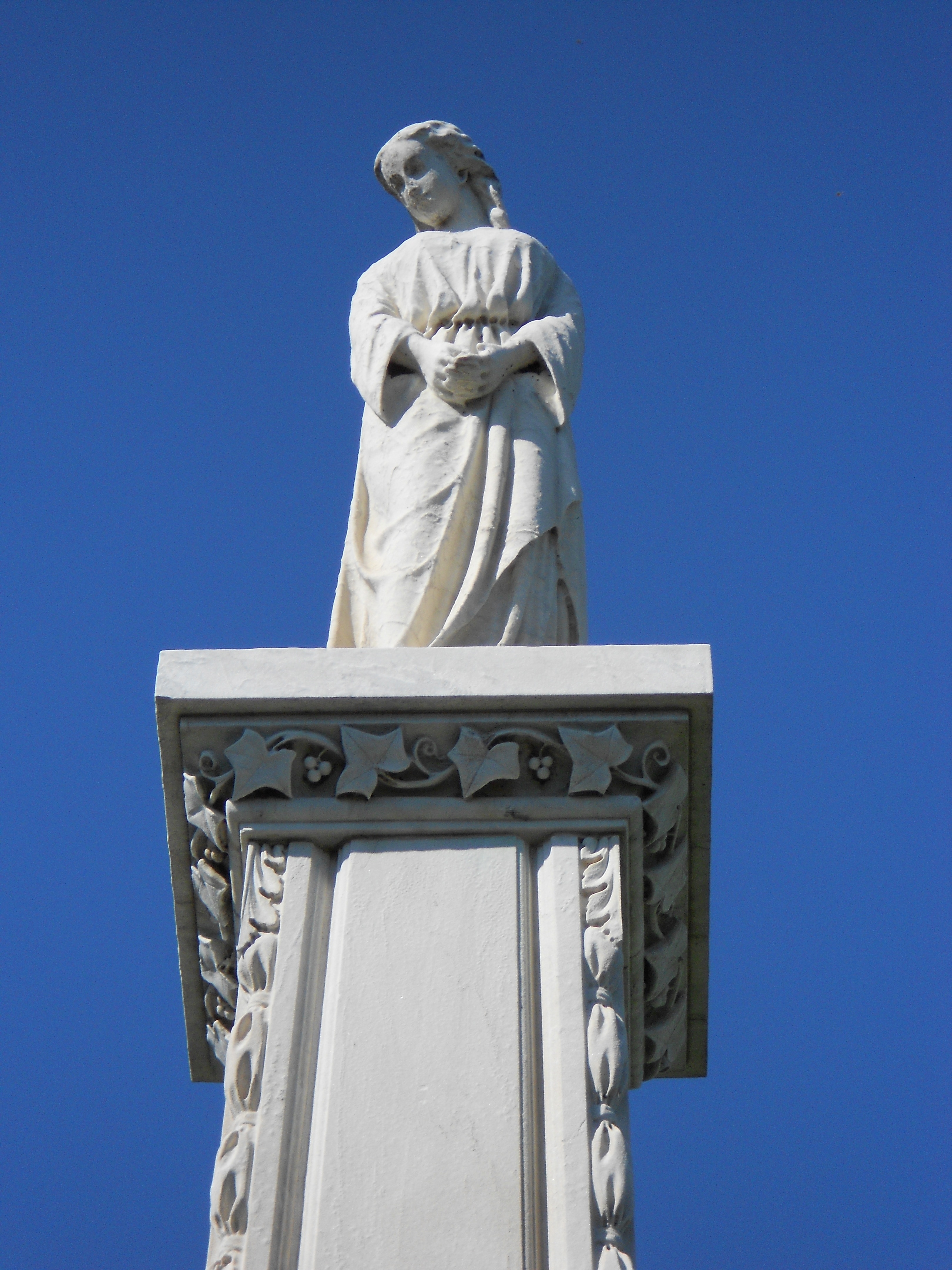 woman statue on white column during daytime
