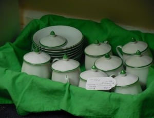 close photo of ceramic canister and saucer lot in basket thumbnail