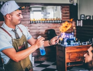 man holding flaming tool and spray bottle thumbnail