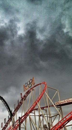 Amusement park rides under dark cloudy sky thumbnail