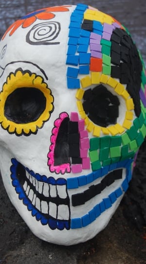 blue red yellow and multicolored day of the dead skull figurine thumbnail