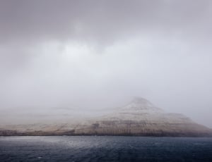 island under cloudy sky during daytime thumbnail
