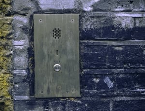 black steel door bell on black concrete wall thumbnail