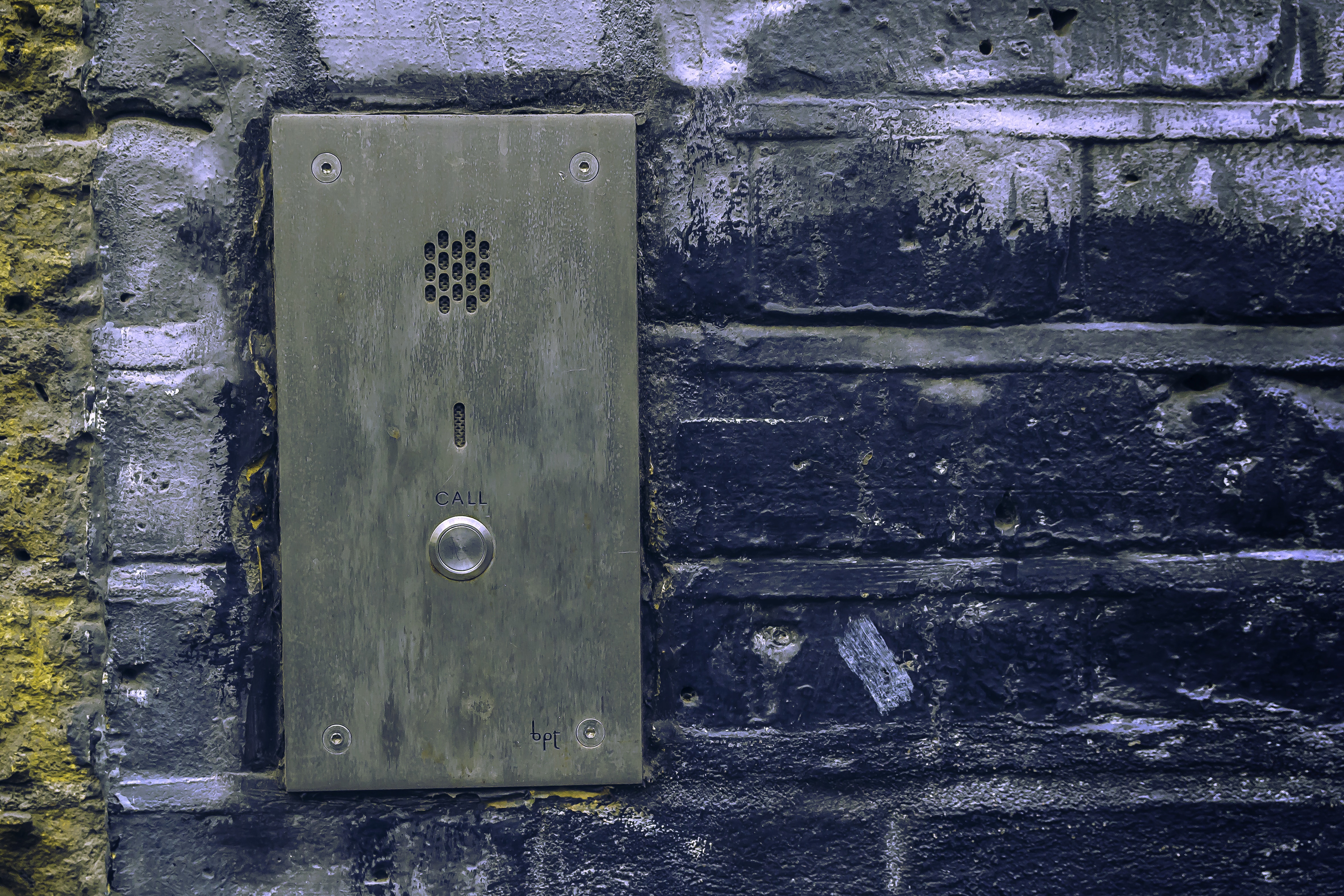 black steel door bell on black concrete wall