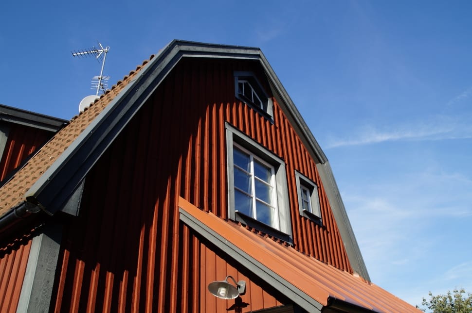 red concrete house with white wind vane preview