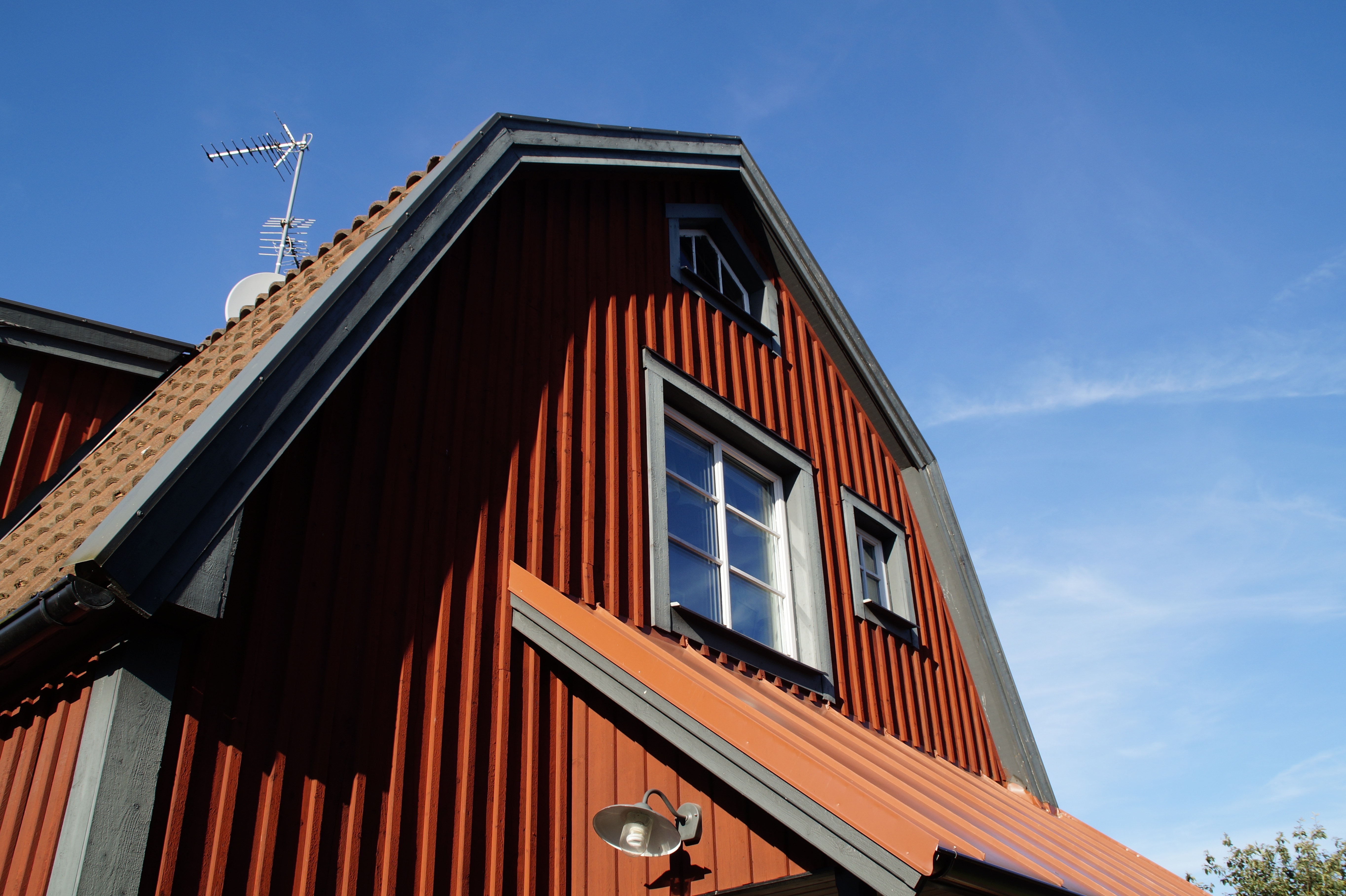 red concrete house with white wind vane