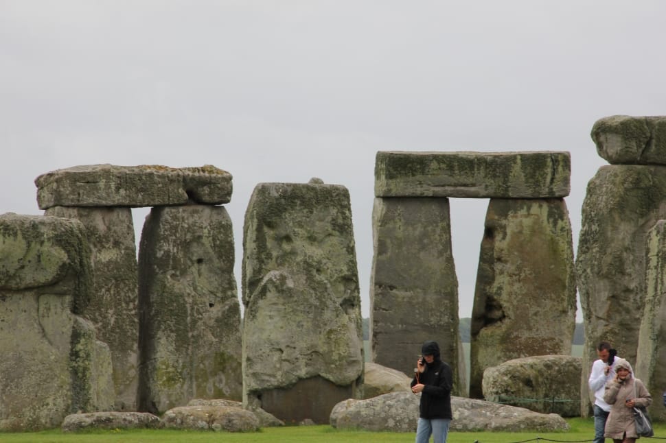 person wearing black jacket and blue jeans standing near stonehenge preview
