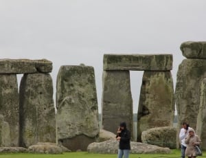 person wearing black jacket and blue jeans standing near stonehenge thumbnail