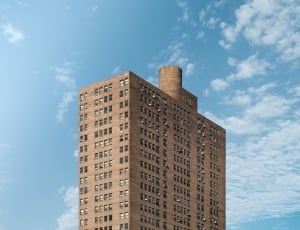 brown building under cloudy sky during daytime thumbnail