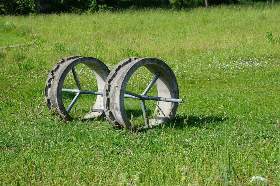 photography of black wheel on green grass field during day time preview