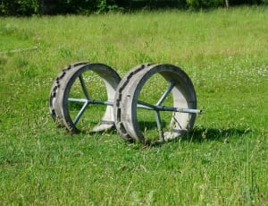 photography of black wheel on green grass field during day time thumbnail
